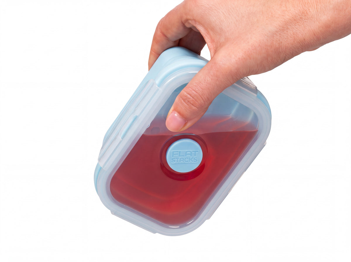 Holding a light blue Flat Stacks container of red liquid sideways, sealed tight with no leaks